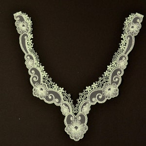 May include: A delicate white lace trim with a floral design. The trim is perfect for adding a touch of elegance to any project.