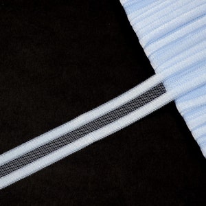 May include: A light blue elastic trim with a white mesh insert. The trim is on a black background.