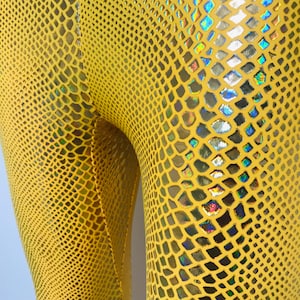 Puede incluir: Leggings amarillas con estampado de piel de serpiente y detalles iridiscentes.
