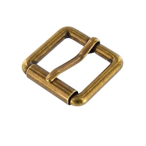 May include: A square, antique brass-colored roller buckle. The buckle has a rectangular frame with rounded corners and a central roller bar. The metal has a slightly aged appearance, suggesting vintage or rustic appeal. Ideal for leathercraft or bag making.
