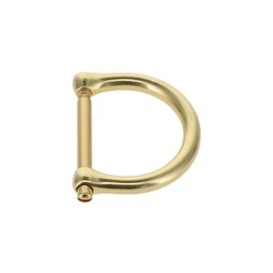 K&ouml;nnte beinhalten: Eine goldfarbene D-Ring-Schnalle aus Metall mit einem glatten, geschwungenen Au&szlig;enrahmen und einem geraden, abnehmbaren horizontalen Steg, der durch einen kleinen Schraubmechanismus an einer Seite befestigt ist, zur Verbindung von Riemen.