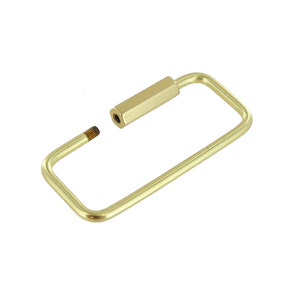 May include: A gold-toned metal key ring with a rectangular shape and a screw-on attachment.