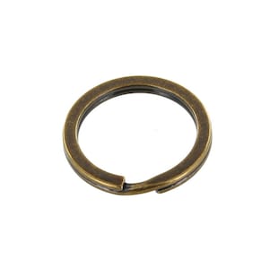 Puede incluir: Un solo llavero de metal de color dorado antiguo. El anillo es redondo y tiene una abertura de anillo dividido.