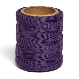 May include: A spool of purple waxed thread for sewing and crafting.