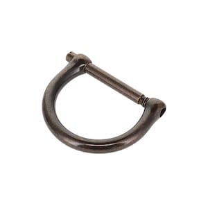 Puede incluir: Una hebilla de metal en forma de D con acabado en bronce oscuro, que cuenta con una barra recta extraíble de rosca que conecta los dos extremos del marco curvo. El herraje tiene una textura metálica lisa y un perfil redondeado en todo.