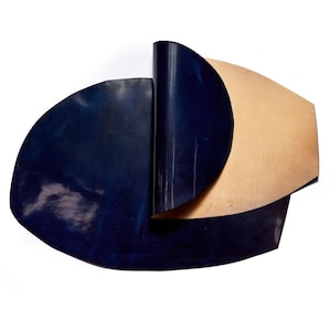 May include: Three pieces of leather in different shades of blue and brown. The leather is folded and arranged in a semi-circular shape.