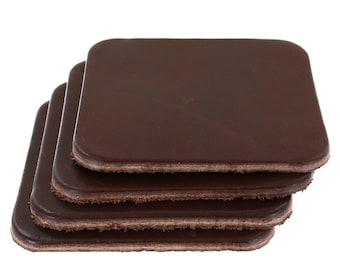 Può includere: Una pila di quattro sottobicchieri quadrati in pelle marrone scuro con angoli arrotondati. Ogni sottobicchiere presenta una superficie superiore liscia e un bordo grezzo testurizzato visibile sui lati, che mostra lo spessore del materiale in una disposizione uniforme.