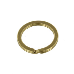 Könnte beinhalten: Ein goldfarbener Schlüsselring aus Metall mit einem einfachen, runden Design.