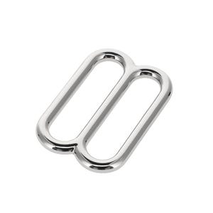 May include: A silver-coloured metal slider buckle with a smooth, reflective finish. The hardware features a rectangular frame divided by a central bar, creating two distinct openings for webbing or strap adjustment in various sewing and craft projects.