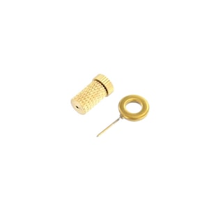 May include: A gold-colored metal pin with a round head and a threaded base. The pin is designed for attaching items to fabric.