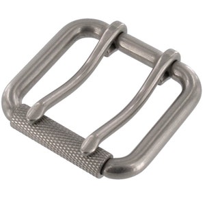 May include: A silver metal buckle with a textured roller bar. The buckle has two loops for attaching a strap.