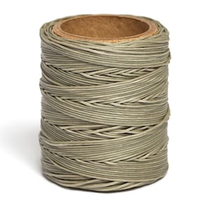 May include: A spool of light brown waxed thread, wound tightly around a cardboard tube.