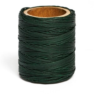 May include: A spool of dark green waxed thread.