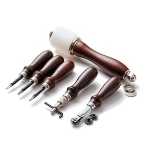 May include: A selection of leathercraft tools, featuring a mallet with a white head and a dark wooden handle, alongside various awls and specialist tools. The tools have dark wooden handles and silver details, set against a white background.
