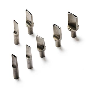 Puede incluir: Un conjunto de siete puntas de soldador plateadas, cada una con un borde de corte en ángulo único. Las puntas están dispuestas sobre un fondo blanco, mostrando sus diversas formas y tamaños. Diseñadas para trabajos de soldadura de precisión.