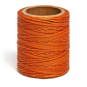 May include: A spool of orange waxed thread.
