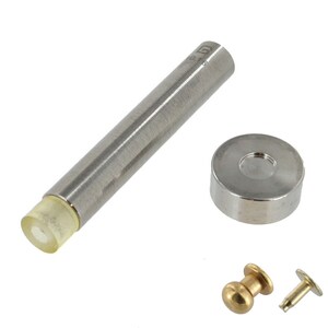 Puede incluir: Un conjunto de herramientas metálicas para hacer manualidades de cuero. El conjunto incluye un punzón, una tapa, un poste y un remache. El punzón es plateado con una punta de plástico amarilla. La tapa, el poste y el remache son plateados.