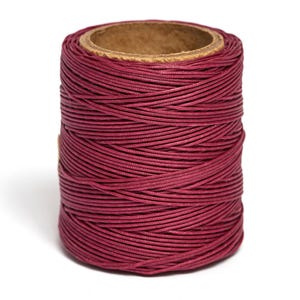 May include: A spool of deep burgundy red waxed cotton thread.