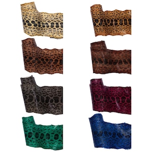 May include: Eight rolls of textured material featuring a repeating snake skin pattern in various colours including gold, brown, dark grey, magenta, green, and blue. Each roll displays a distinct scale texture and a unique colour combination.