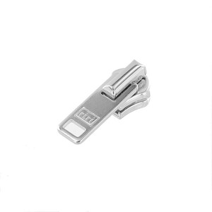 May include: A silver metal zipper pull with the word "riri" embossed on the rectangular tab. The zipper pull is designed for use in clothing or accessories. The image shows the zipper pull against a white background.