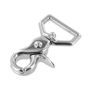 May include: Silver-toned metal swivel hook with a D-ring. The hook has a spring-loaded latch and a smooth, polished finish.