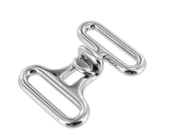 May include: Silver metal buckle with two oval loops. The buckle is designed to connect two straps.
