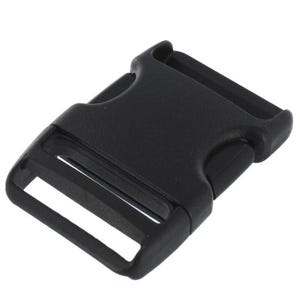 Könnte beinhalten: Schwarze Kunststoff-Schnalle mit seitlicher Freigabe. Die Schnalle hat ein gebogenes Design mit zwei Schlitzen für Riemen und einen zentralen Auslösemechanismus. Die Gesamtform ist rechteckig mit abgerundeten Kanten. Das Material scheint ein haltbarer Kunststoff zu sein.