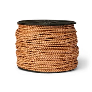 May include: A spool of light brown braided cord wrapped tightly around a black plastic reel. The cord features a consistent woven texture and a tan color throughout the entire length of the material wound onto the central cylindrical core.