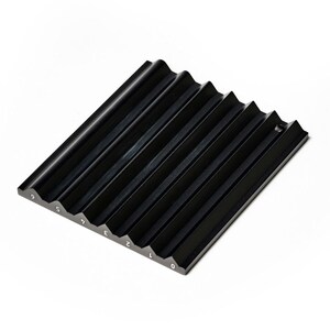 May include: A black, angled, grooved tray with white numbers 0 through 9 along one edge. The tray has a series of parallel, wave-like grooves. The object is made of a solid, matte black material and sits on a white surface.
