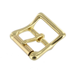 May include: A gold-toned metal buckle with a smooth, rounded finish. The buckle has a rectangular shape with a rounded edge and a single prong.