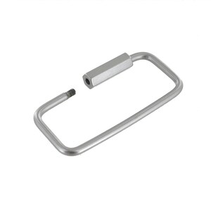 May include: A silver metal key ring with a rectangular shape and a hexagonal screw-on cap.