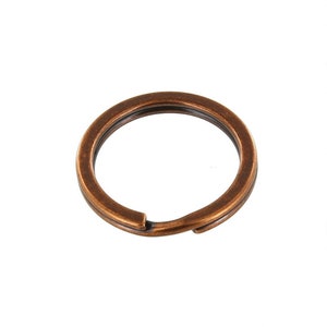 May include: A copper-colored key ring with a smooth, rounded finish. The ring is open and ready to hold keys.