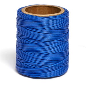 May include: A spool of blue waxed thread. The thread is wound tightly around a cardboard spool.