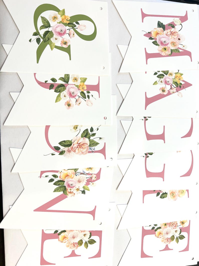 May include: A pink and green floral banner with the word "WELCOME" spelled out in pink letters. Each letter is decorated with a floral arrangement of pink, yellow, and white flowers.