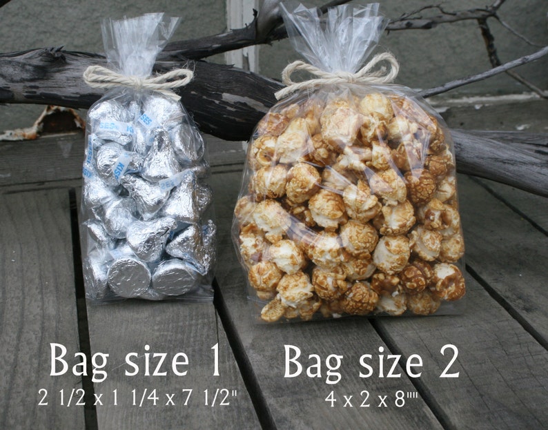 Puede incluir: Dos bolsas de pl&aacute;stico transparentes con cierre de torsi&oacute;n. La bolsa de la izquierda est&aacute; llena de besos de chocolate envueltos en papel de aluminio plateado. La bolsa de la derecha est&aacute; llena de palomitas de ma&iacute;z con caramelo. El texto debajo de las bolsas dice "Tama&ntilde;o de la bolsa 1 2 1/2 x 1 1/4 x 7 1/2" y "Tama&ntilde;o de la bolsa 2 4 x 2 x 8"
