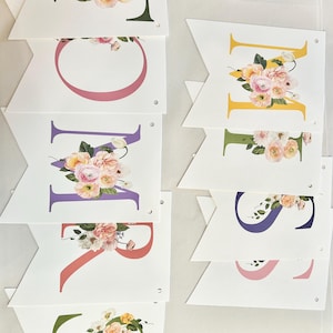 May include: A floral banner with the word "SPRING" spelled out in colorful letters. Each letter is decorated with a bouquet of pink, white, and yellow flowers.