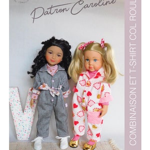 Può includere: Due bambole che indossano abiti diversi. Una bambola indossa una tuta a righe blu e bianca con un motivo floreale rosa sulle maniche. L'altra bambola indossa un pigiama bianco e rosa con un motivo a forma di cuore e accenti dorati. Le bambole sono in piedi davanti a una grande lettera V con un motivo floreale.