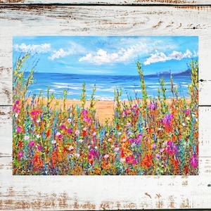 May include: A painting of a beach scene with a blue sky, white clouds, and a blue ocean. The beach is covered in colorful wildflowers.