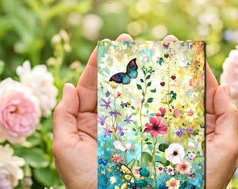 May include: A rectangular art print titled Kathy Symonds Fine Art featuring a vibrant painting of a blue butterfly hovering over a field of colorful wildflowers including pink, white, and purple blossoms against a soft, textured, multi-colored background.