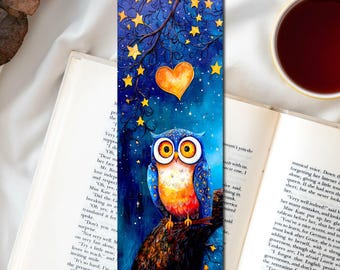 May include: A rectangular bookmark featuring a vibrant painting of a wide-eyed owl perched on a tree branch against a dark blue night sky filled with yellow stars and a single glowing orange heart hanging from a thin branch above.