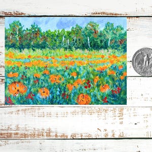 May include: A painting of a field of orange pumpkins in a green field with a blue sky and trees in the background.