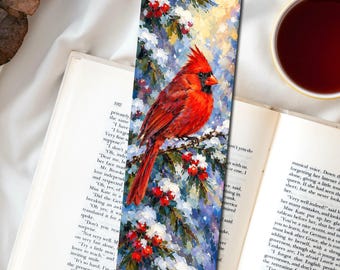 May include: A rectangular bookmark featuring an oil painting of a bright red cardinal bird perched on a snowy pine branch with clusters of red berries. The artwork displays thick, textured brushstrokes in shades of white, blue, and green.