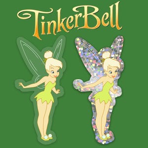 K&ouml;nnte beinhalten: Zwei Aufkleber mit Tinkerbell, einer Fee mit gr&uuml;nen Fl&uuml;geln und einem gr&uuml;nen Kleid. Ein Aufkleber hat einen Glitzer-Hintergrund und der andere einen wei&szlig;en Hintergrund.