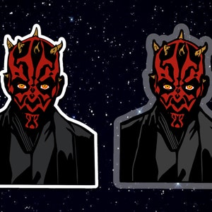 May include: A red and black Darth Maul character sticker with a white border. The sticker is on a black background with white stars.