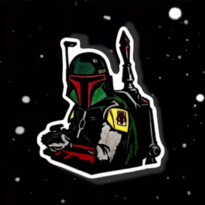 May include: A black and green Star Wars Boba Fett character sticker with a red and yellow design. The sticker is on a black background with white dots.