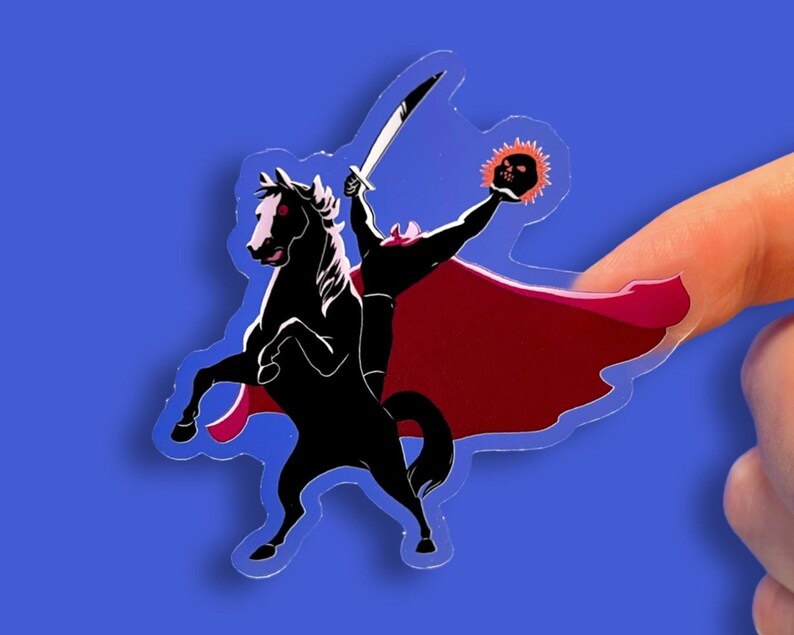 Puede incluir: Una pegatina transparente que representa a un jinete sin cabeza montado en un caballo negro encabritado. El jinete, en silueta, sostiene una espada y una calavera en llamas. La pegatina tiene una capa roja sobre un fondo azul.