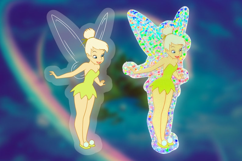 K&ouml;nnte beinhalten: Zwei Versionen eines Tinkerbell-Aufklebers. Eine ist ein klarer Aufkleber mit einem gr&uuml;nen Kleid und die andere ist ein holografischer Aufkleber mit einem gr&uuml;nen Kleid.