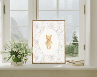 May include: A framed watercolor print featuring a brown teddy bear inside an oval, set against a floral and diamond pattern. The print has a wooden frame and is displayed on a windowsill with a bouquet of white tulips.