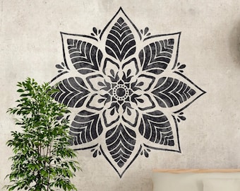 May include: A white couch with wooden storage boxes sits in front of a wall with a black mandala design and a round clock with black numbers.