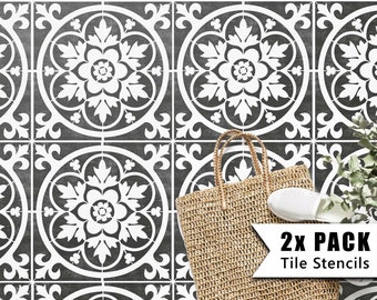 May include: Two white tile stencils with a floral design. The stencils are on a dark gray background. The text "2X PACK Tile Stencils" is in the lower right corner of the image.